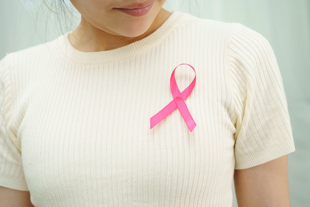 A patient wearing a pink ribbon in support of breast cancer
