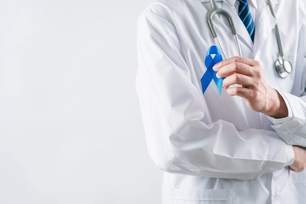 A doctor promoting colon cancer awareness with a blue ribbon